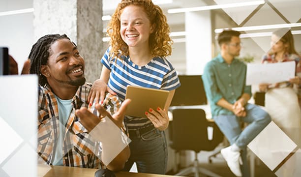 Duas pessoas sorriem no escritório da empresa