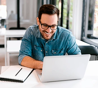 Homem trabalha com notebook em escritório