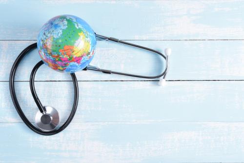 Estetoscópio e globo em um fundo de madeira, simbolizando o mês mundial da saúde.
