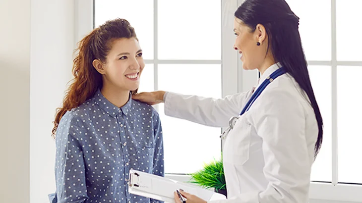 Médica e paciente conversando na consulta médica