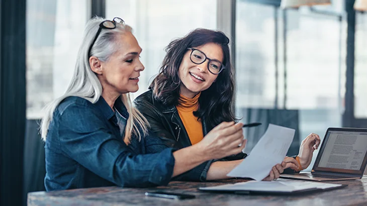 Duas mulheres olhando para um papel.