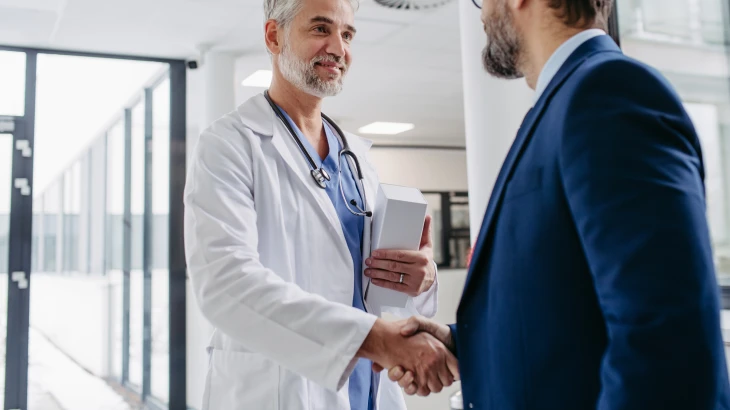 Médico apertando a mão de homem