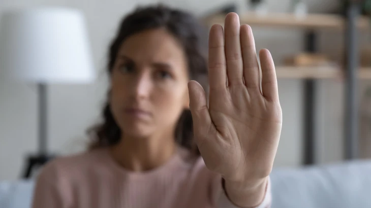 Mulher com o braço estendido e a mão aberta para frente