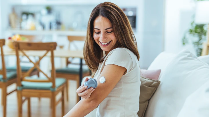 Mulher olhando para o braço e medindo a diabetes