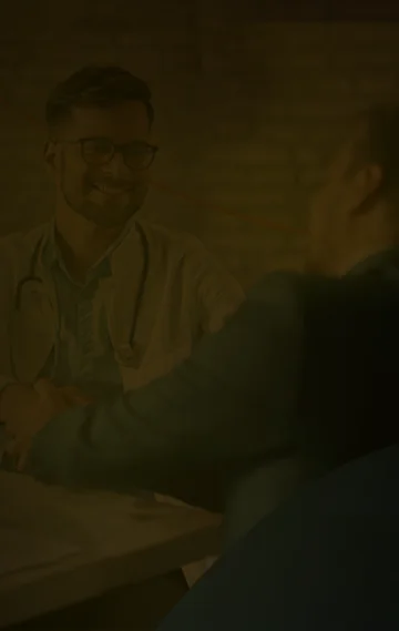 Homem de negócios cumprimentando médico que sorri.